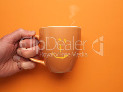 Orange coffee mug with a smiling icon