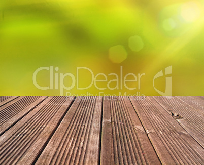 Emtpy wooden table with blurry nature background and flares