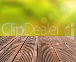 Emtpy wooden table with blurry nature background and flares