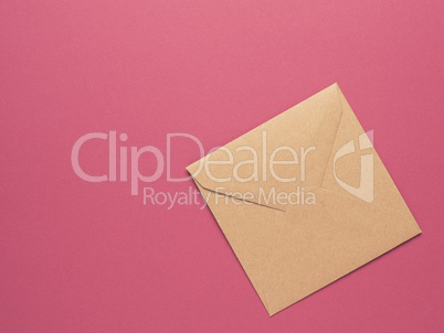 An envelope made from recycled paper on a red background with co