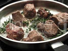 Organic beef fillet with rosemary and thyme in a stainless steel