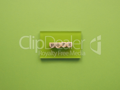 Wooden blocks with the word hope on a green background