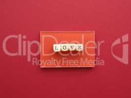 Wooden blocks with the word love on a red background