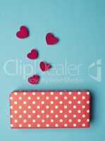 Dotted gift box with red wooden heart shapes