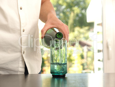 Mid aged man pouring water into a glass