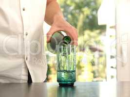 Mid aged man pouring water into a glass