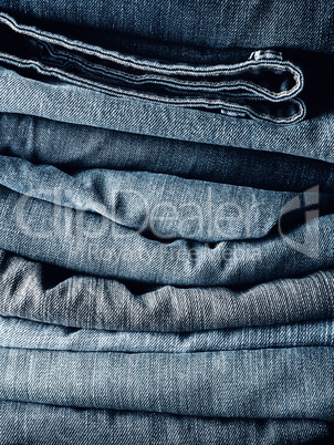 Stacked blue jeans using as background