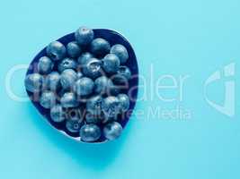 Tasty organic blueberries on a blue paper background