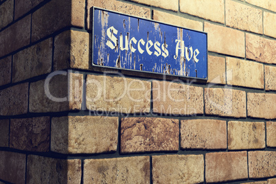 Old rusty street sign with the street name Success Avenue