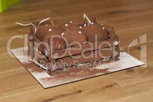 Brown chokolate sweet potato cake on a wooden dark background. Fudge nuggets with cream photo