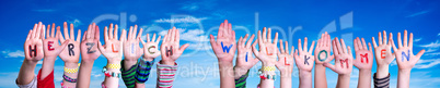 Children Hands Building Word Herzlich Willkommen Means Welcome, Blue Sky