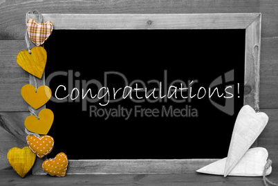Balckboard With Yellow Heart Decoration, Text Congratulations, Gray Wooden Background