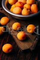 Mellow apricots with knife over cutting board