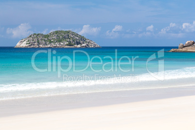 Beach with white sand and blue water with a view to the small is