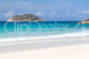 Beach with white sand and blue water with a view to the small is