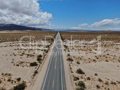 Aerial view of endless desert straight dusty asphalt road in Joshua Tree Park. USA.