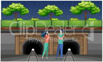 couple standing near railway track and talking to each other