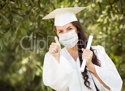 Female Graduate in Cap and Gown Wearing Medical Face Mask