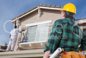 Contractor Overlooking Painter Paitning House