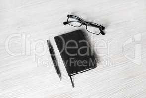 Notebook, glasses and pencil