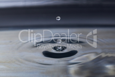 A small water drop fall on water surface