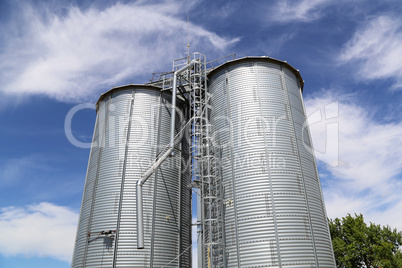 Metallic silos in white over the sky