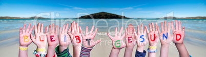 Kids Hands Holding Word Bleibt Gesund Means Stay Healthy, Ocean Background