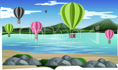 hot air balloons are flying in air on the beach near mountains