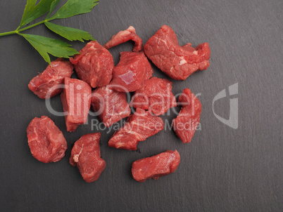 Raw organic beef on a slate plate with space for text