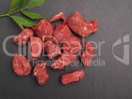Raw organic beef on a slate plate with space for text