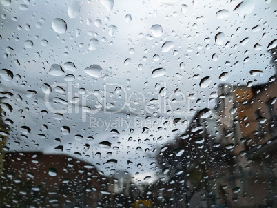 City street seen through rain drops on the car windshield. Bad Autumn weather in Rainy day. Windshield window of car with raindrops on glass windscreen.