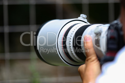 The telephoto lens in the hands of the photographer