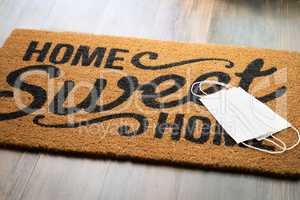 Medical Face Masks Rests on Home Sweet Home Welcome Mat Amidst T