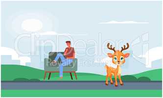 man sitting in a park looking at deer