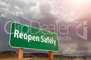 Reopen Safely Green Road Sign Against Ominous Stormy Cloudy Sky