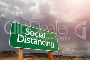 Social Distancing Green Road Sign Against Ominous Stormy Cloudy
