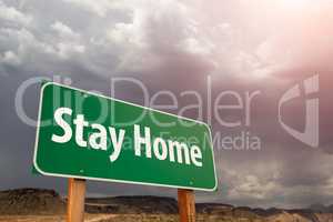 Stay Home Green Road Sign Against Ominous Stormy Cloudy Sky