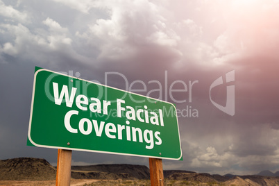 Wear Facial Coverings Green Road Sign Against Ominous Stormy Clo