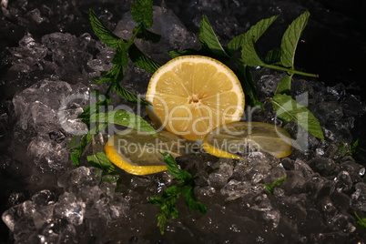 The lemon cut into slices lies in the ice