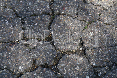 A fragment of an old cracked asphalt road