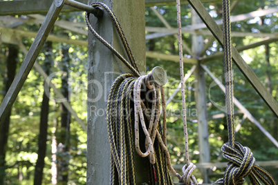 A long rope coil hangs on a metal structure