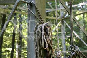 A long rope coil hangs on a metal structure