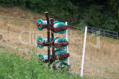 close up of a electrical wire fence around a pasture