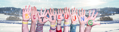 Kids Hands Holding Word Betreuung Means Day Care, Snowy Winter Background