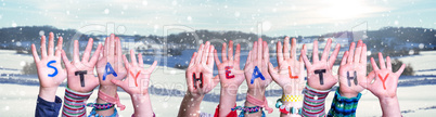 Kids Hands Holding Word Stay Healthy, Snowy Winter Background