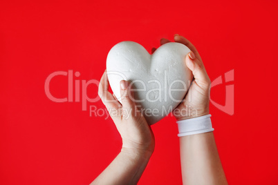White heart in female hands