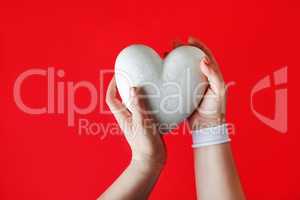 White heart in female hands