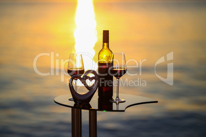 Composition of glasses and wine bottles at sunset