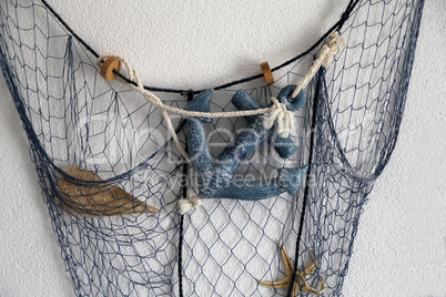 Composition from the fishing net on the wall of the house
