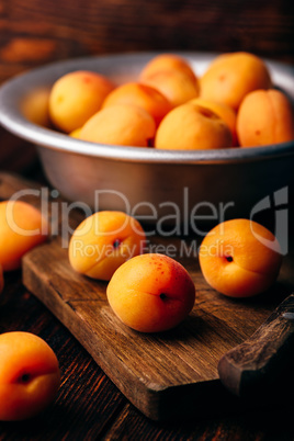 Mellow apricots with knife over cutting board